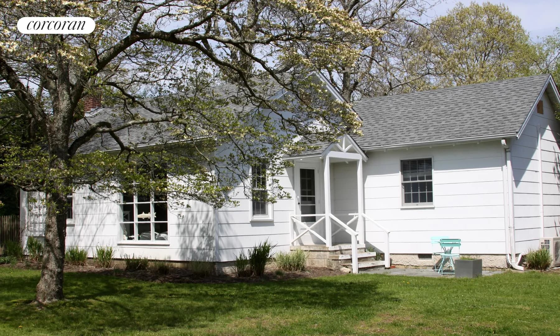 Shelter Island beach bungalow — front exterior with green lawn and flowering tree