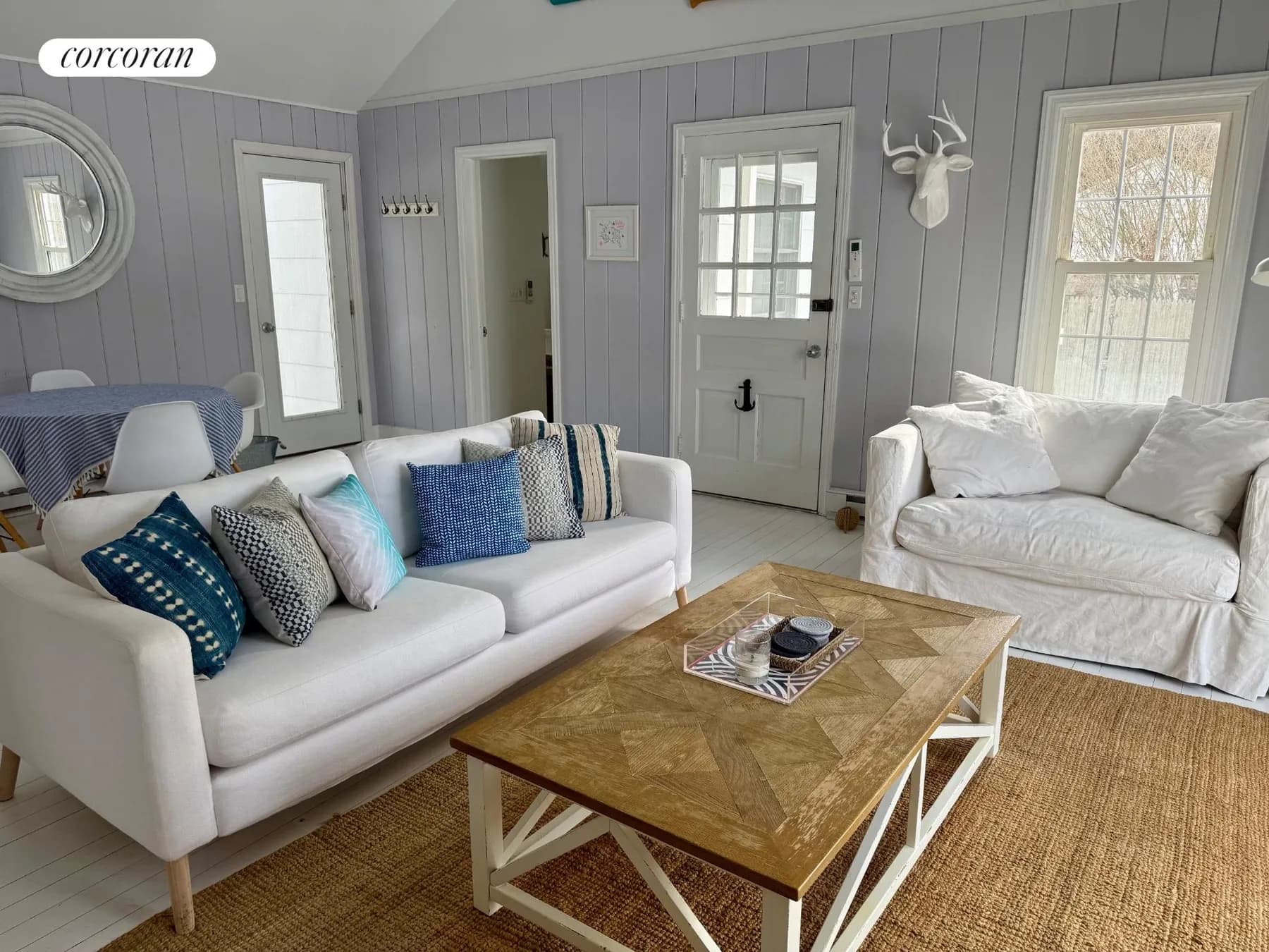 Living room with grey shiplap walls, coastal pillows, and jute rug