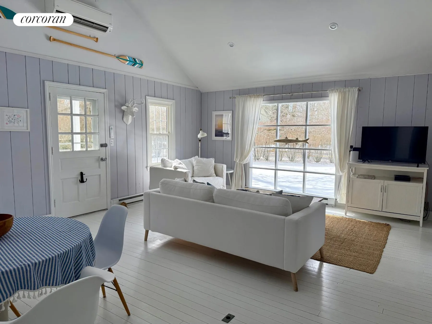 Open living room with vaulted ceiling, TV area, and decorative oars