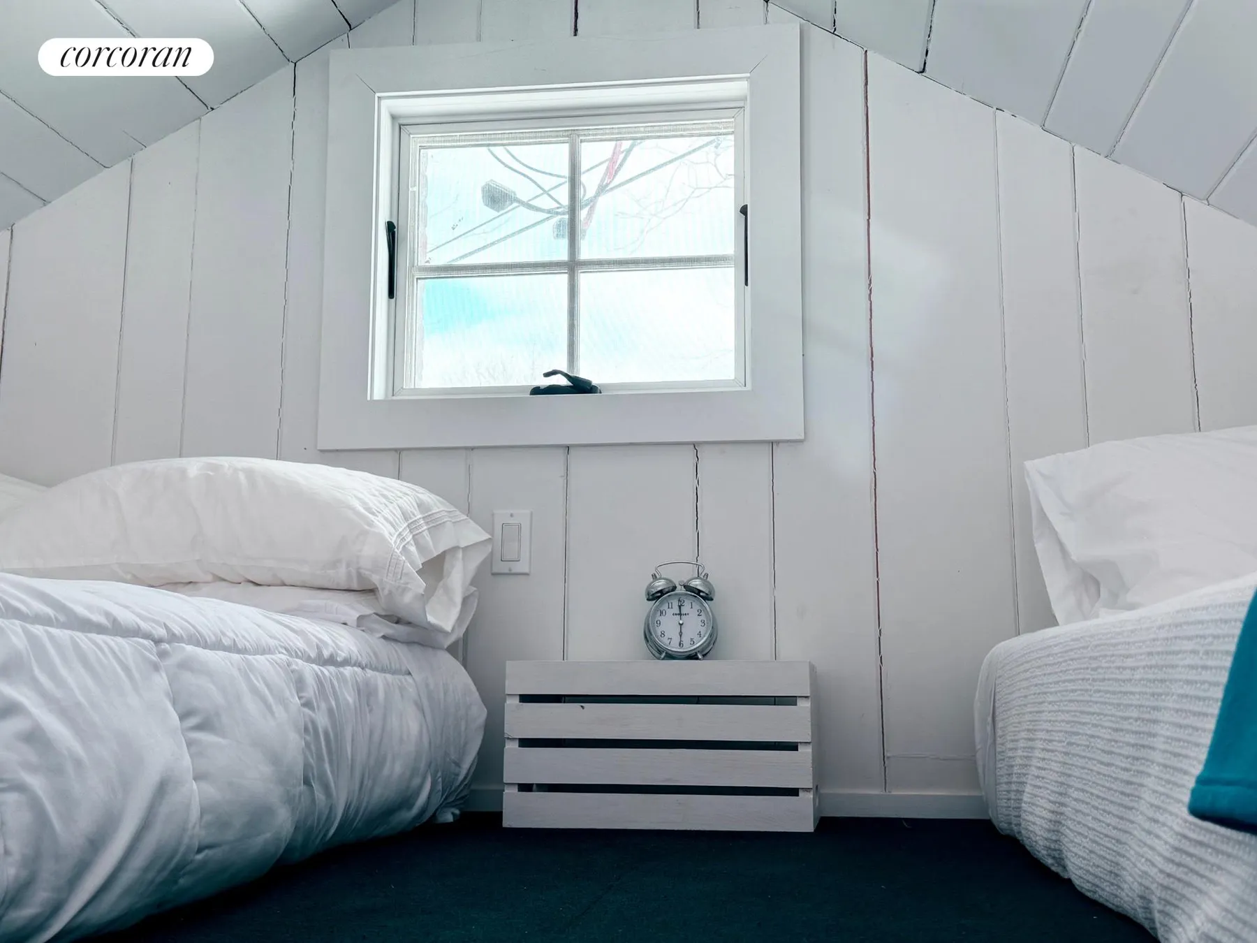 Loft sleeping area with two double beds in a cozy A-frame space