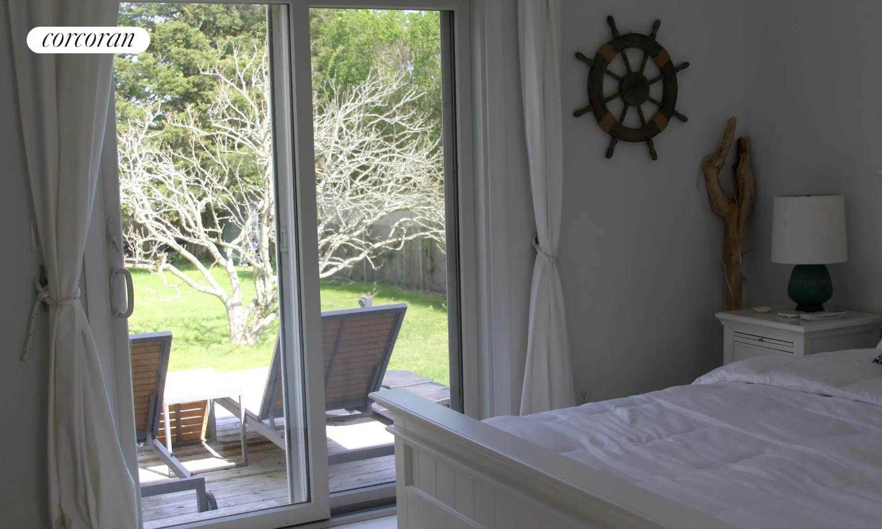 Master bedroom view toward sliding glass doors opening to the deck and yard